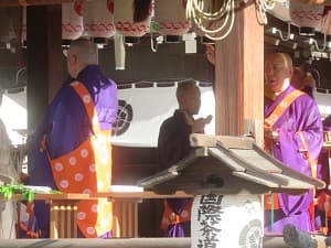 お経を唱えながら紙を撒く